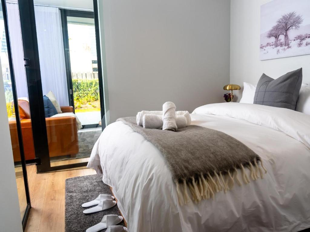 sypialnia z białym łóżkiem z dywanem w obiekcie Luxurious Executive Apartment, Ellipse, Waterfall, Midrand w mieście Midrand