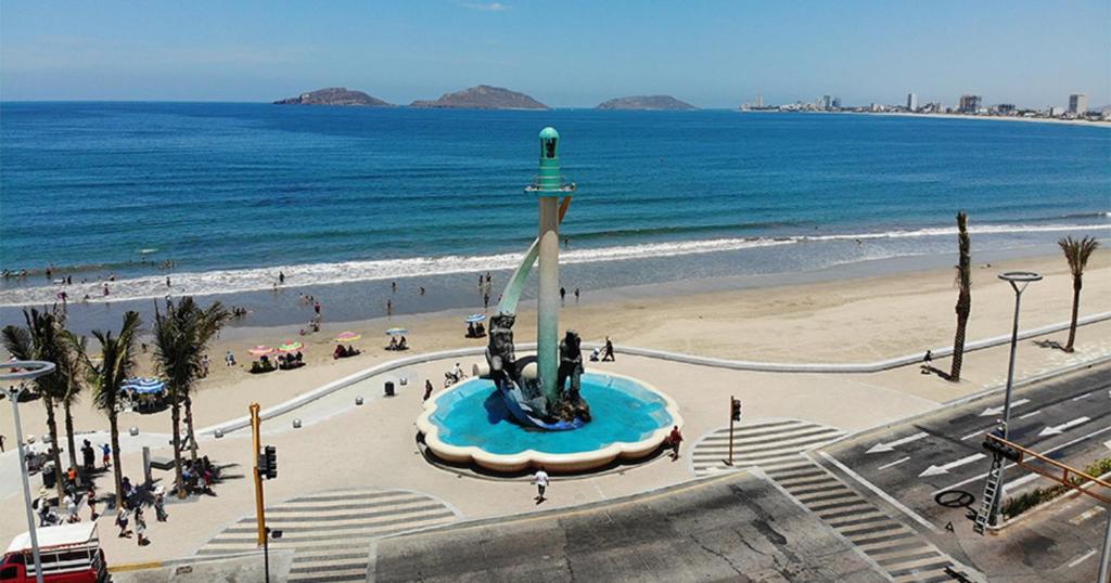 a view of a beach and the ocean with a statue at Malecón Casa Grande Económica Gran Ubicación in Mazatlán