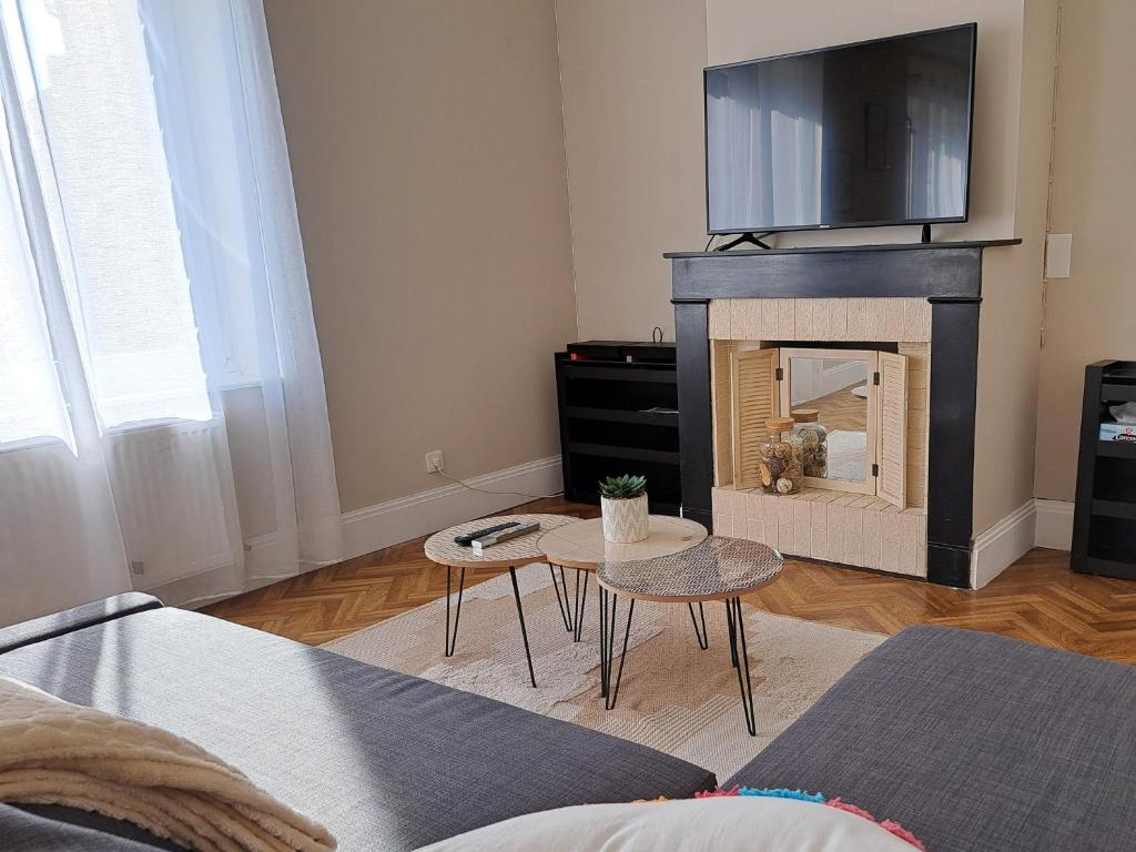 un salon avec une cheminée avec une télévision au-dessus dans l'établissement Au gîte de la Matelote, à Grand-Fort-Philippe