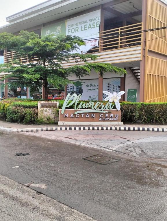 ein Gebäude mit einem Schild vor einer Straße in der Unterkunft Plumera Homes in Lapu Lapu City