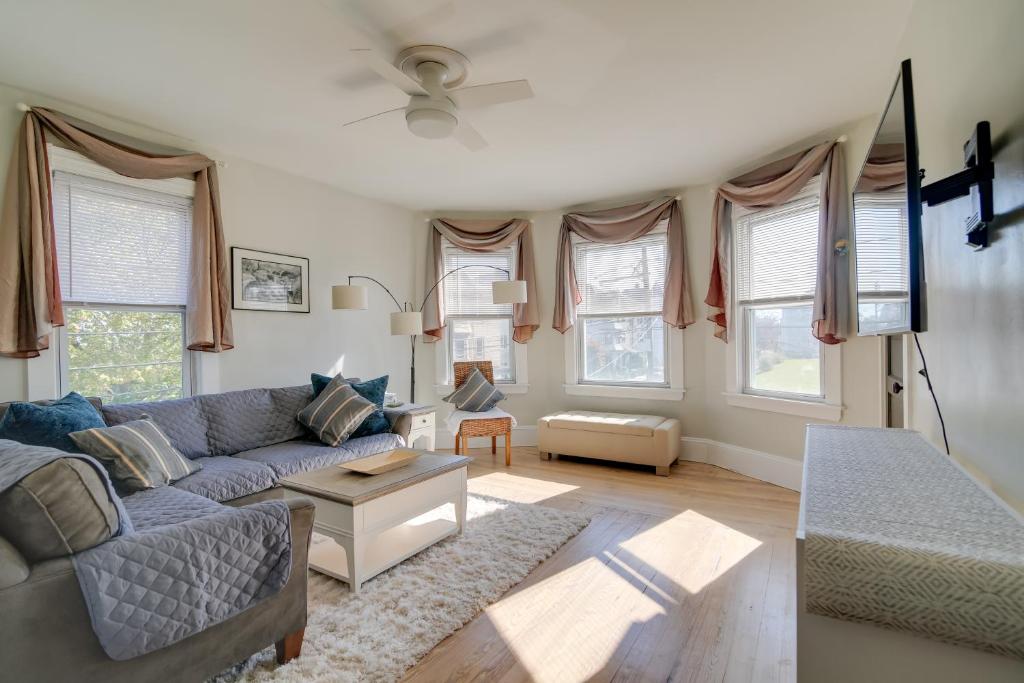 uma sala de estar com um sofá e algumas janelas em New Bedford Apartment about 4 Mi to Fort Phoenix Beach em New Bedford