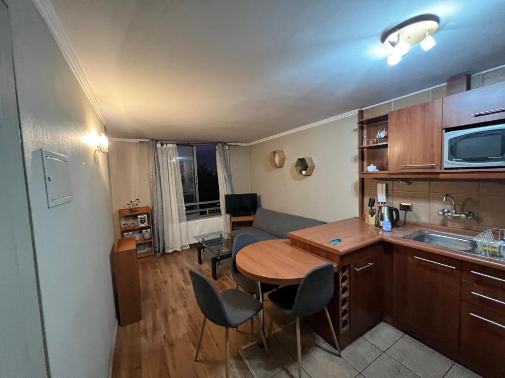 a kitchen and living room with a table and chairs at Departamento Central in Santiago