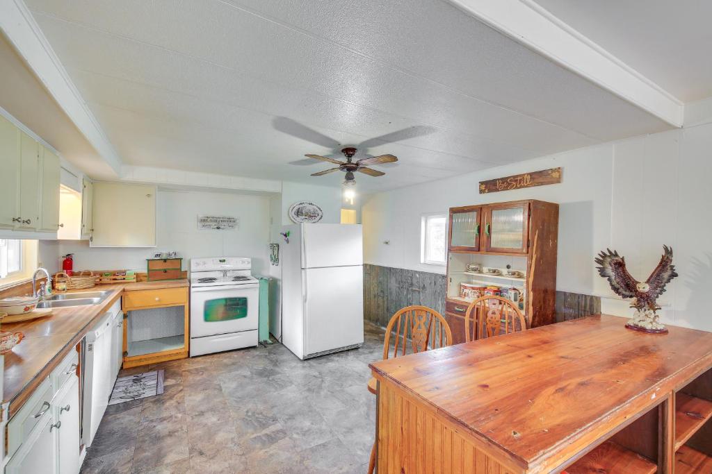 a kitchen with a table and a white refrigerator at Charming Cottage in Libby with Yard Pets Welcome! in Libby