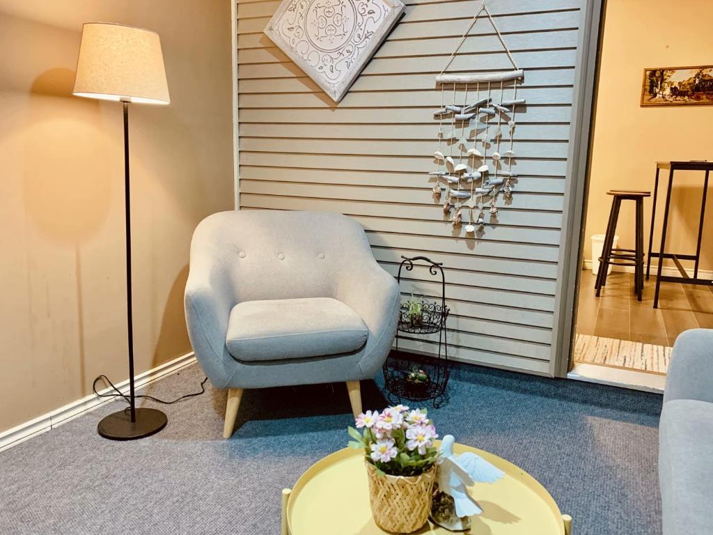 a living room with a chair and a table at Langley 半地下室独立出入温馨卧房-桐花草堂 in Langley