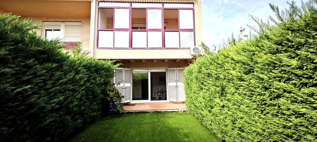 una casa con un patio verde delante de ella en Vistas Río Tormes Huerta Otea en Salamanca