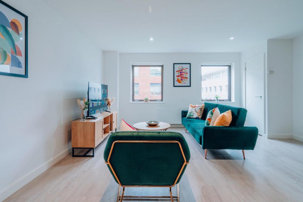 a living room with a green couch and a table at Two Bedroom Urban Retreat in the Heart of Exeter in Exeter