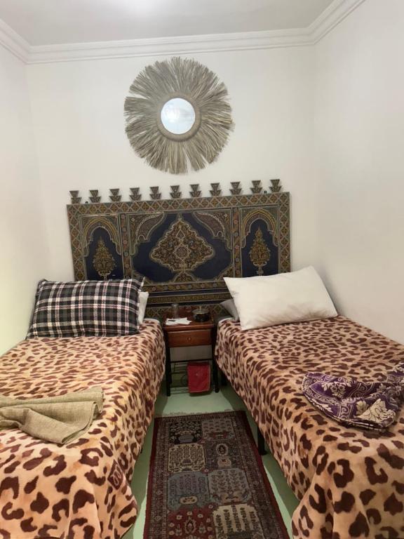 a room with two beds and a mirror on the wall at Peace Hotel in Marrakesh