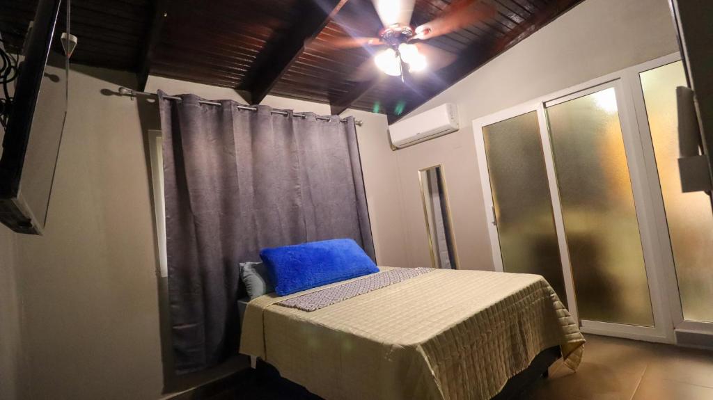 a bedroom with a bed with a blue pillow on it at Smart Inn in San Pedro Sula