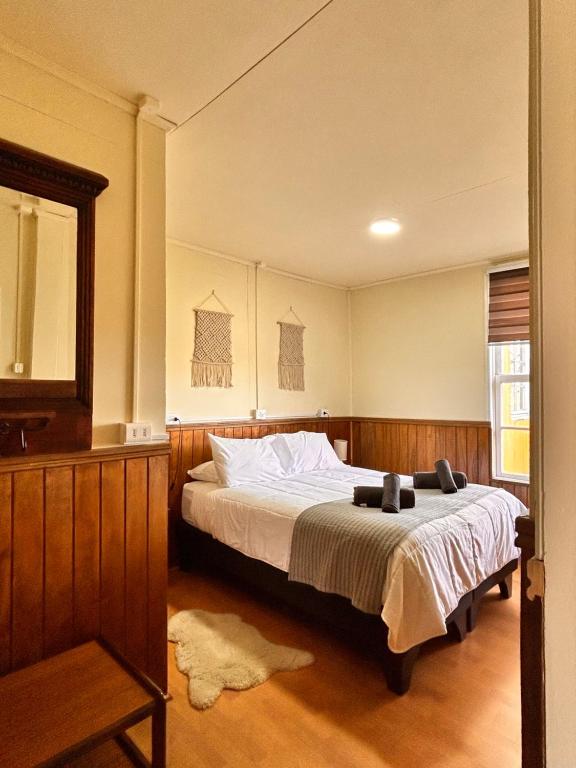 1 dormitorio con cama y espejo en Riverline lodge en Cerro Castillo