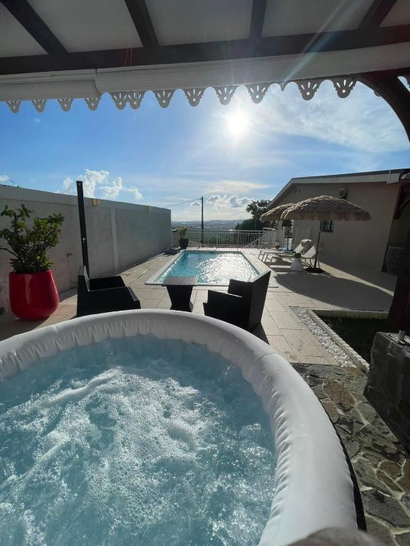 a large swimming pool with a hot tub on a patio at Studio Josie in Le Lamentin