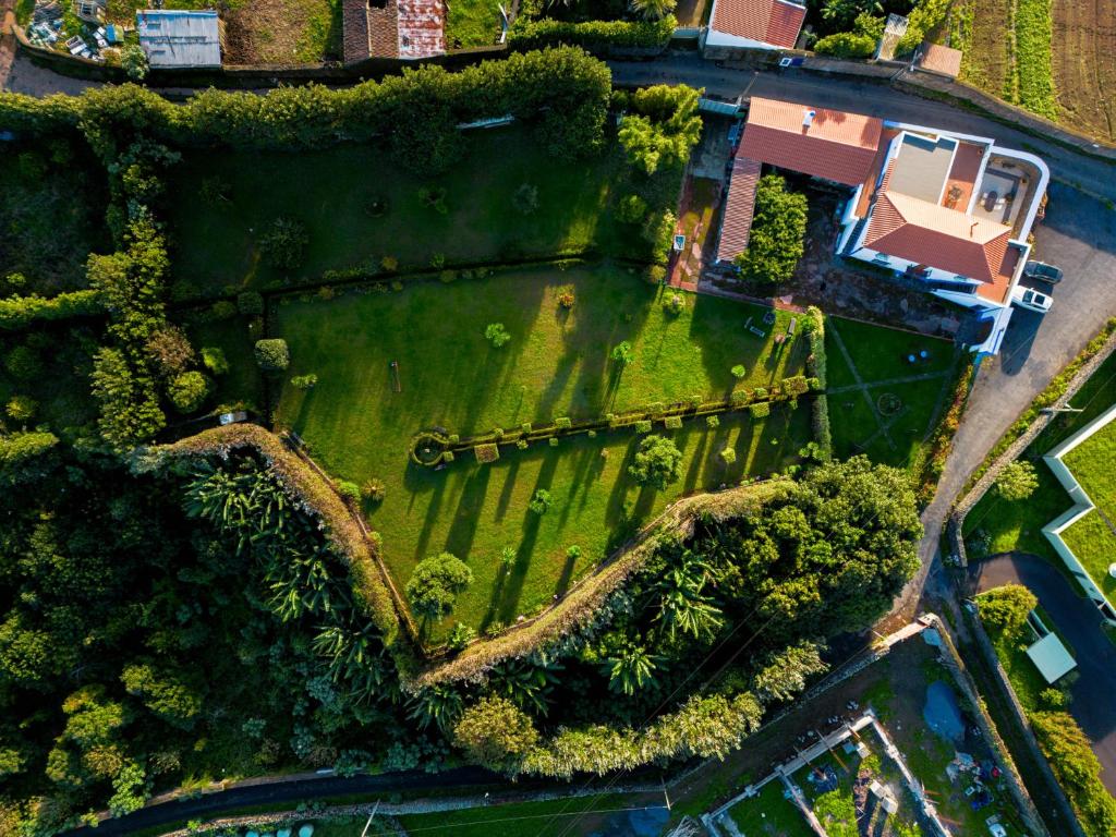 an overhead view of a green field with a house at Quinta Morazes Casas de Campo in Ribeira Grande