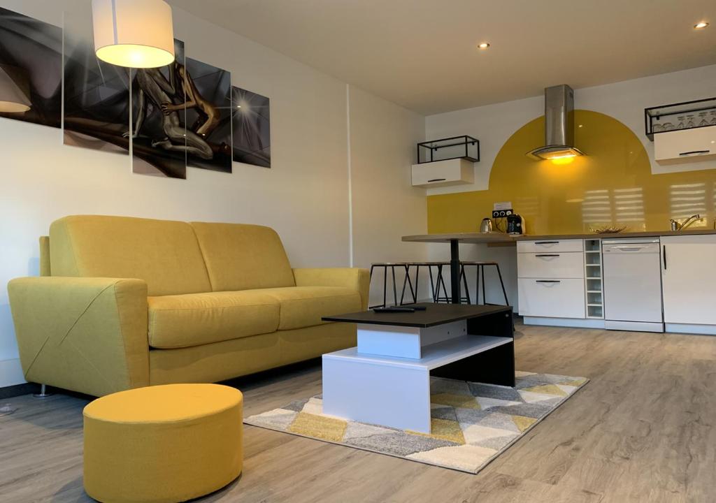 sala de estar con sofá amarillo y mesa en L'Étoile de Mer - Étretat en Le Havre