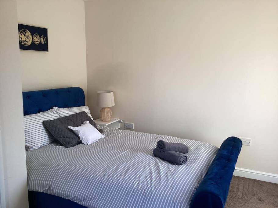 a blue bed with two pillows on it in a room at LovelyHome 4 family& Contractors in Killingbeck