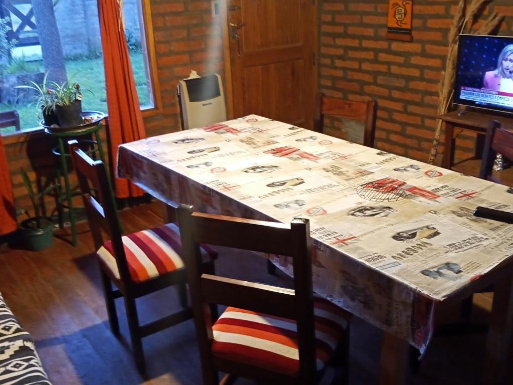 uma mesa e cadeiras com uma mesa e uma televisão em La palmera em Trevelin