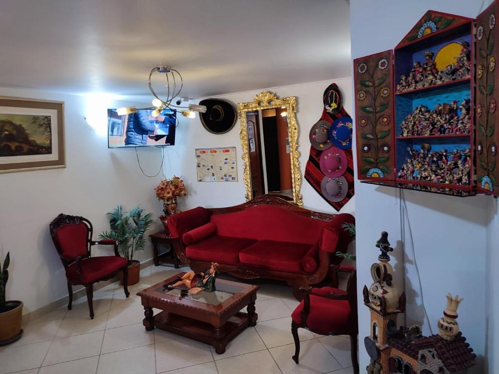 a living room with a red couch and a table at Hotel Misky Samay in Ayacucho