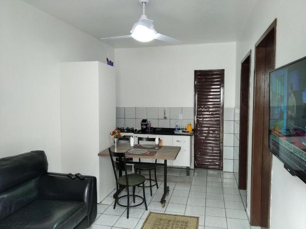 a kitchen with a table and a couch in a room at Apto Prático n.07 in Cascavel