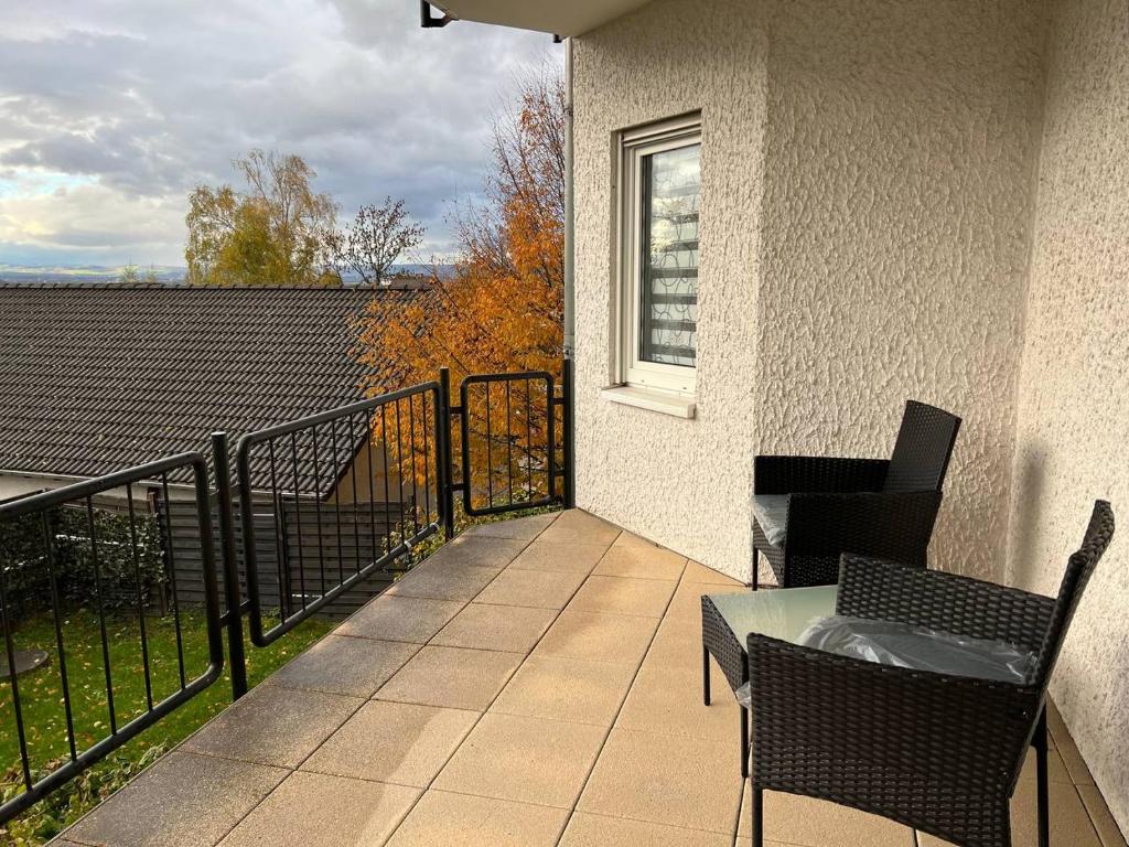 a balcony with a table and chairs and a fence at Sunset Apartment mit Rheinblick in Urbar in Urbar-Mayen-Koblenz