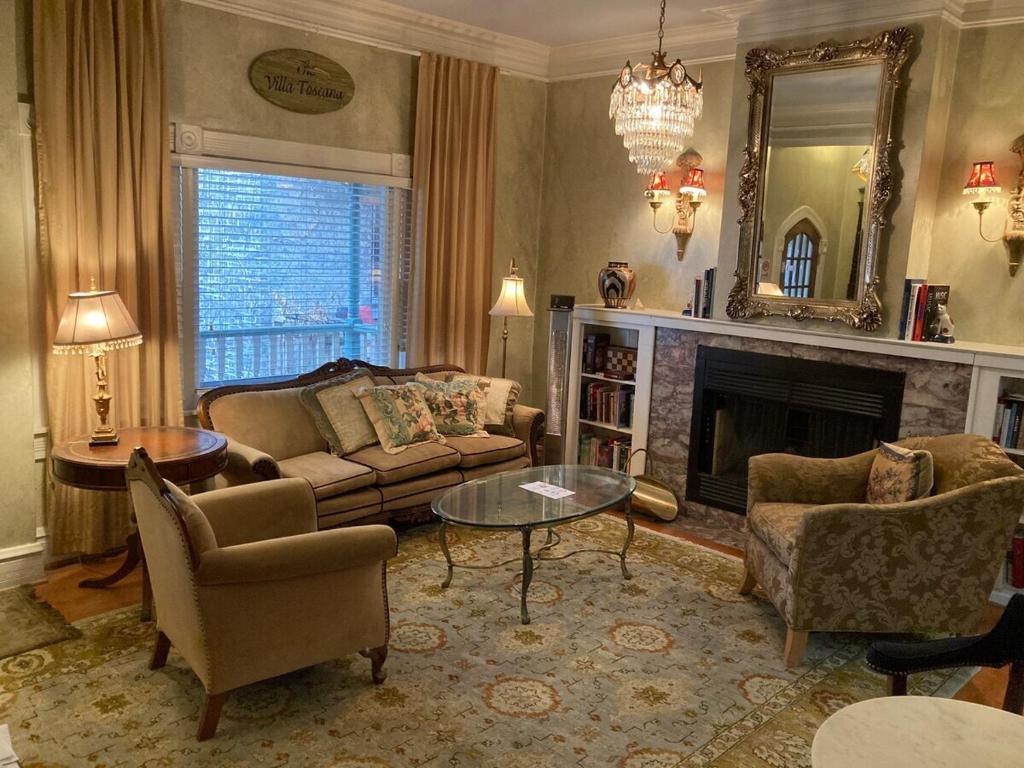 een woonkamer met een bank en stoelen en een open haard bij The Villa Toscana in Chicago
