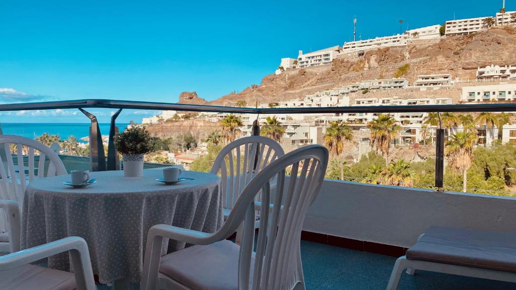a table and chairs on a balcony with a view at Nice flat with terrace in Puerto Rico in Puerto Rico de Gran Canaria