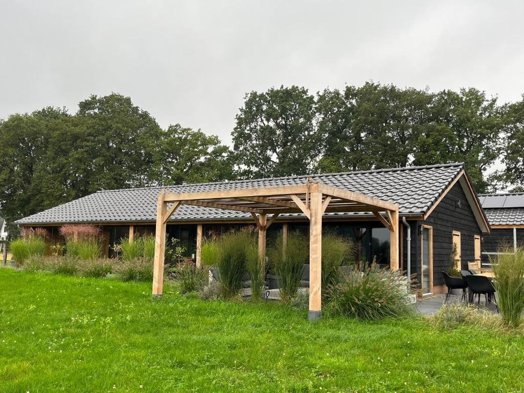 a wooden pavilion in the middle of a field at 't Heidepaleis in Garderen