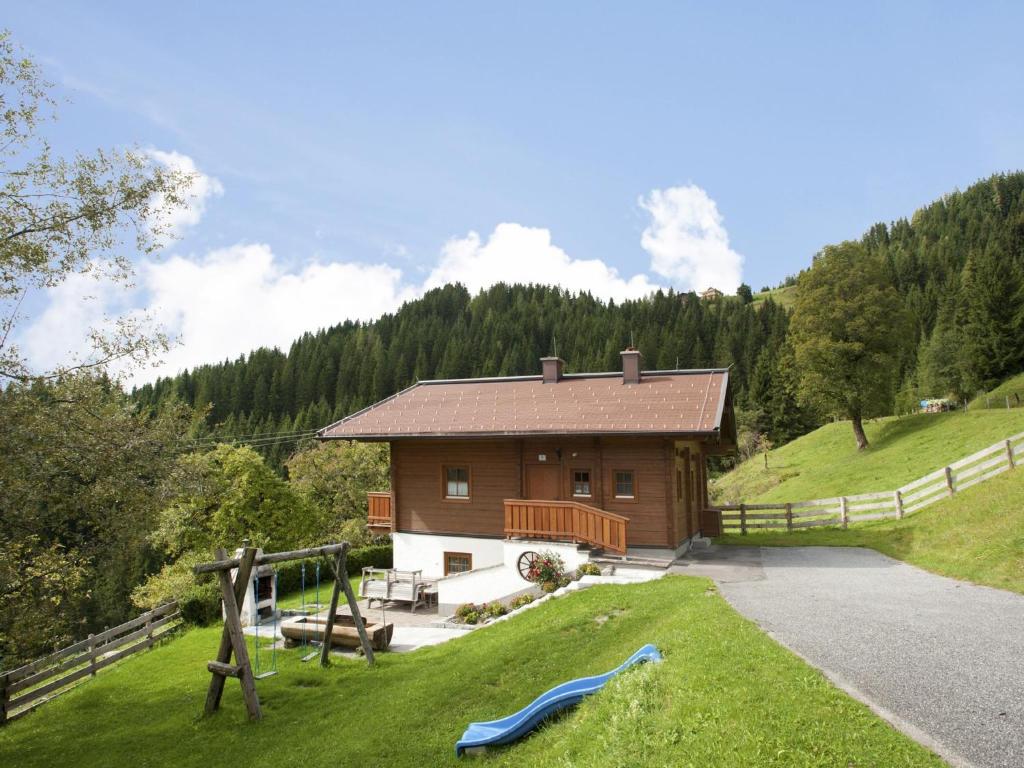 a small house with a playground in the grass at Schüttbach in Wagrain