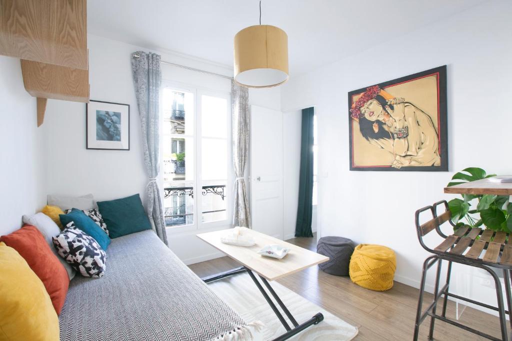ein Wohnzimmer mit einem Sofa und einem Tisch in der Unterkunft Charming 1 Bedroom Marais Hideaway - FB17A in Paris