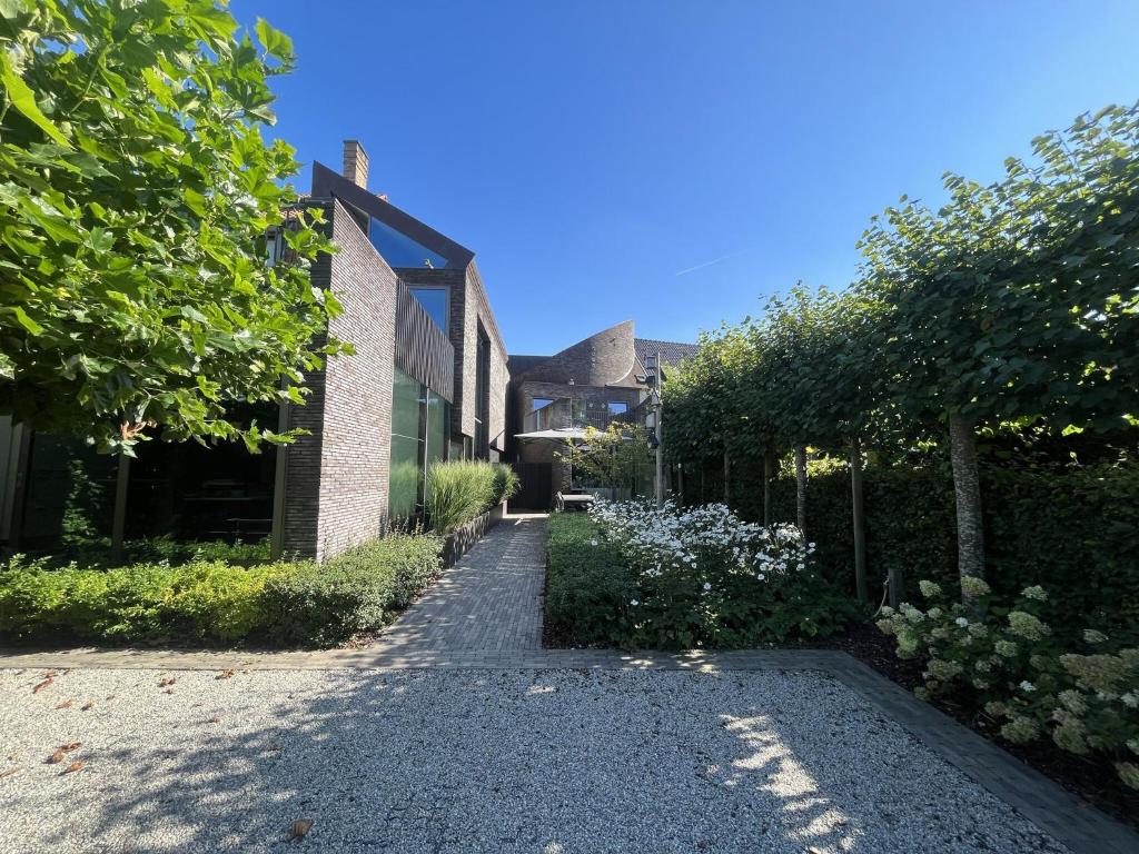 einen Fußweg vor einem Haus mit Bäumen in der Unterkunft Modern holiday home near Bruges and the North Sea in Dudzele