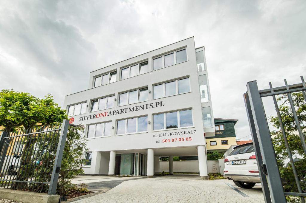 Un bâtiment blanc avec un panneau. dans l'établissement Silver One Apartments, à Gdańsk