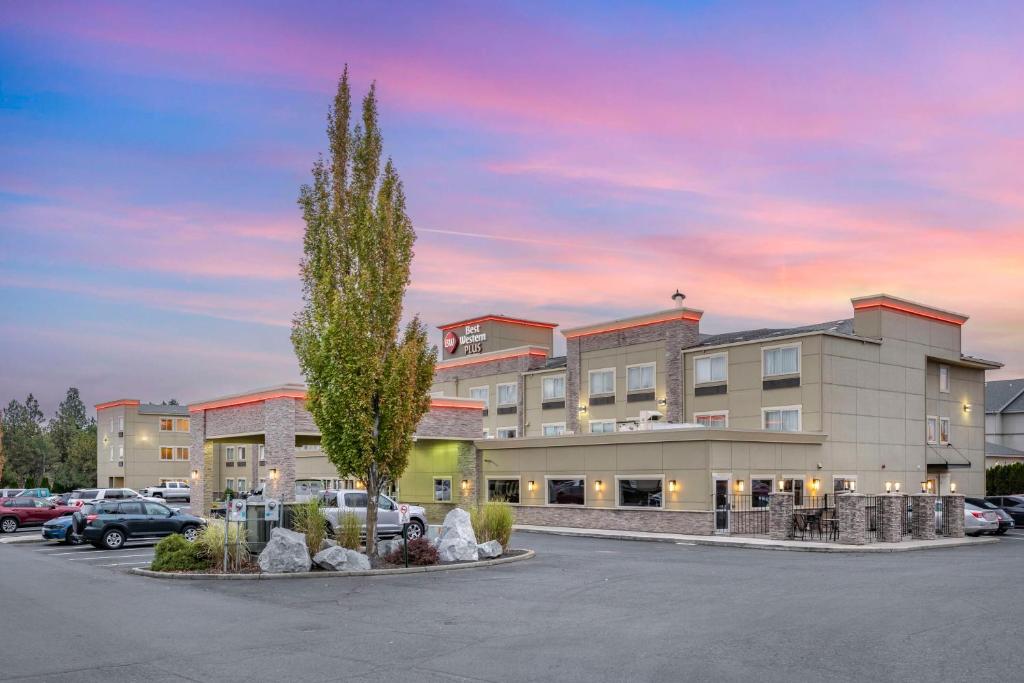 um edifício com uma árvore num parque de estacionamento em Best Western PLUS Peppertree Airport Inn em Spokane