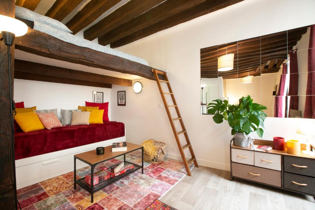 - une chambre avec un lit en mezzanine et un canapé rouge dans l'établissement Authentic apartment in center of Parisian Marais, à Paris