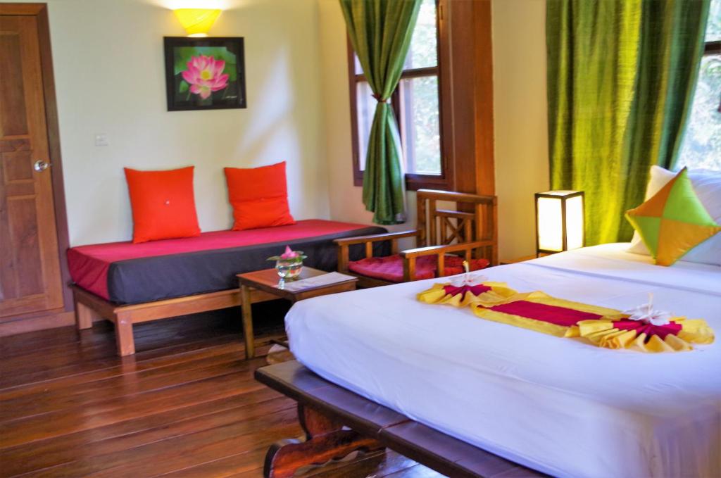 um quarto de hotel com duas camas e uma janela em Maisons Wat Kor em Battambang