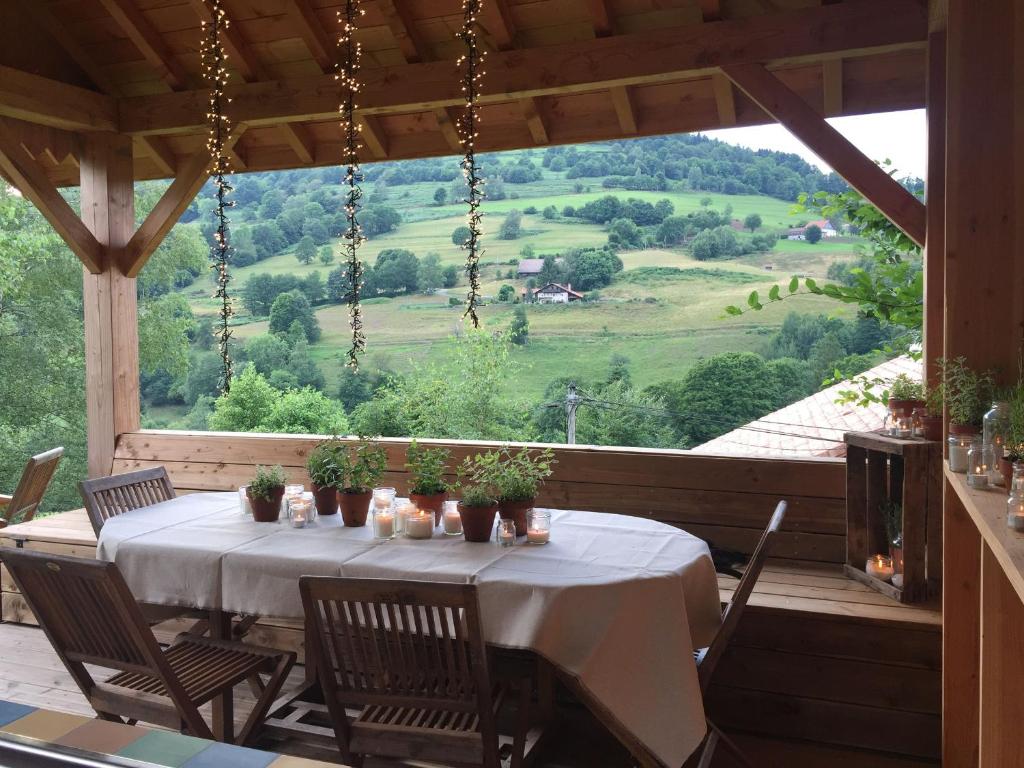een tafel op een veranda met uitzicht op de bergen bij Gîte Fresse-sur-Moselle, 3 pièces, 6 personnes - FR-1-589-43 in Fresse-sur-Moselle