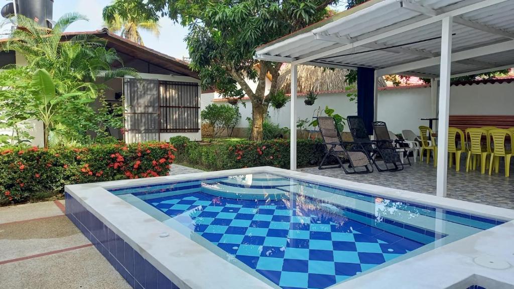 una piscina con azulejos blancos y azules a cuadros en un patio trasero en Casa vacacional con Jacuzzi privado y BBQ, en Carmen de Apicalá