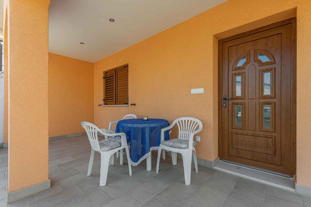 - une salle à manger avec une table, des chaises et une porte dans l'établissement Apartments in Porec - Istrien 44236, à Poreč