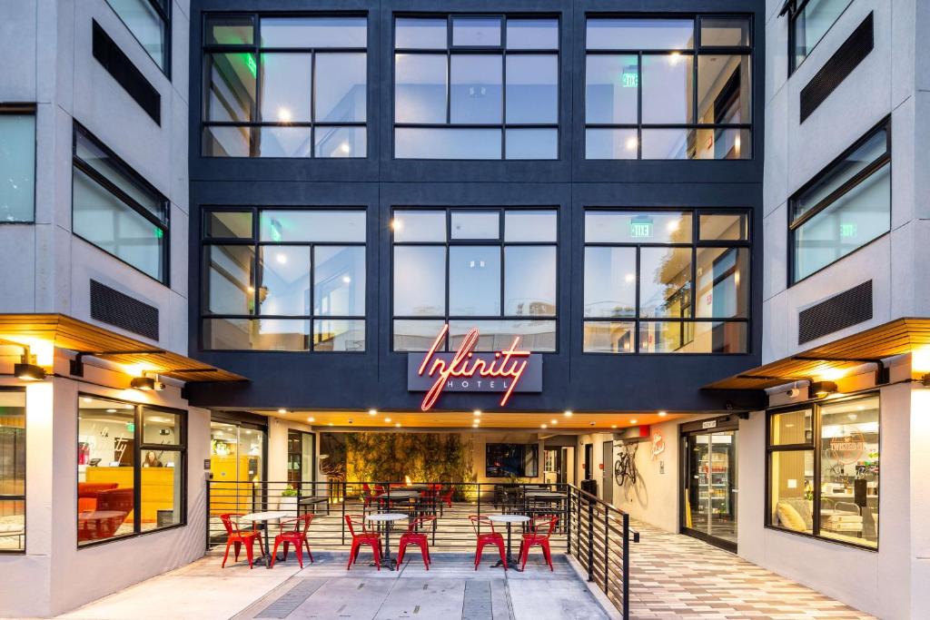 een restaurant met rode tafels en stoelen voor een gebouw bij Infinity Hotel San Francisco, Tapestry Collection by Hilton in San Francisco