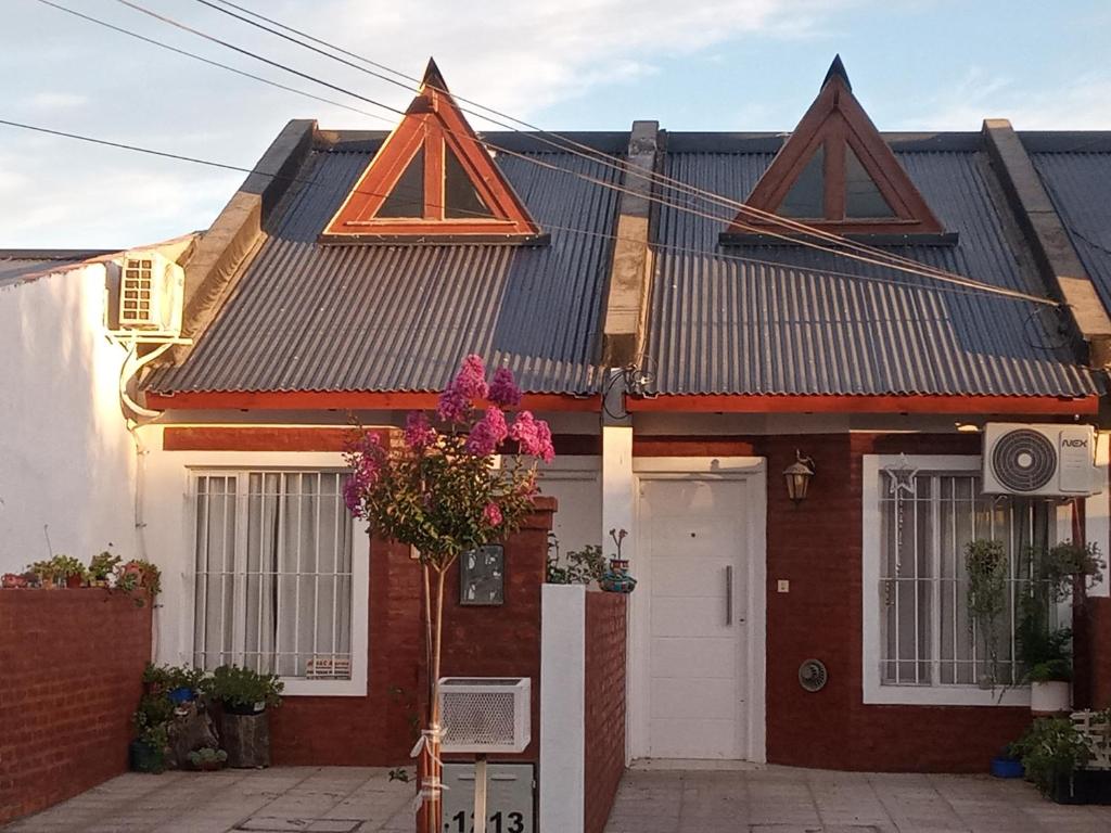 een rood bakstenen huis met een dak bij Ensueños in Trelew