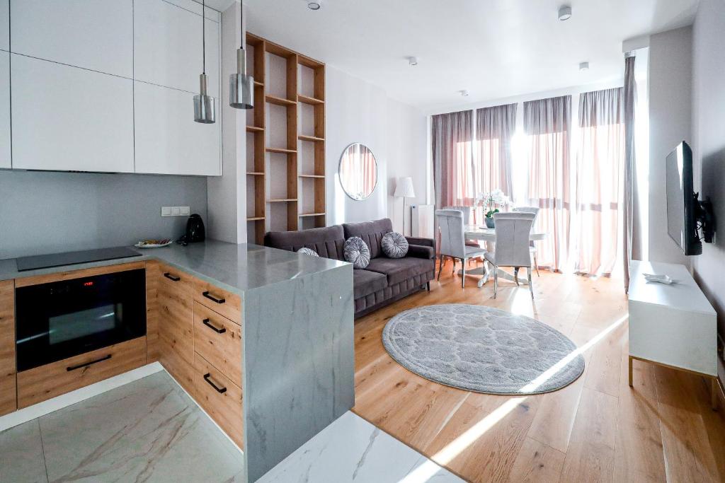 cocina y sala de estar con sofá y mesa en Wola Tower 3 rooms, 16th floor with a view, 80m2, free garage, en Varsovia