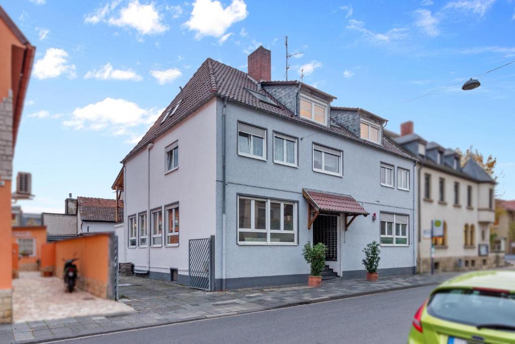 une grande maison blanche sur le côté d'une rue dans l'établissement Family&Friends 2, à Ludwigshafen