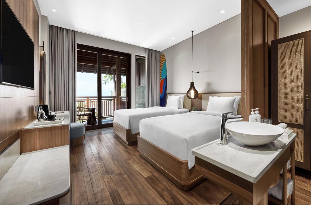 a hotel room with a bed and a sink at Holiday Inn Resort Bali Canggu by IHG in Canggu