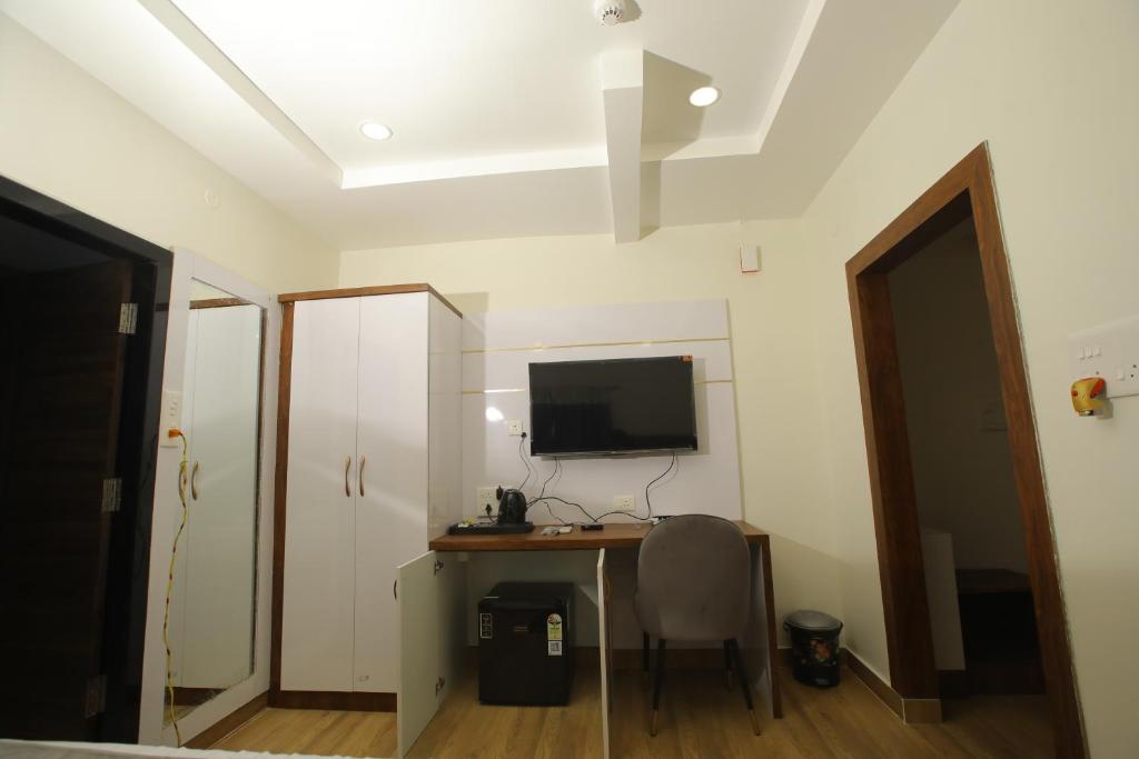 a room with a desk with a computer and a monitor at RADHA RANI RESIDENCY in Khammam