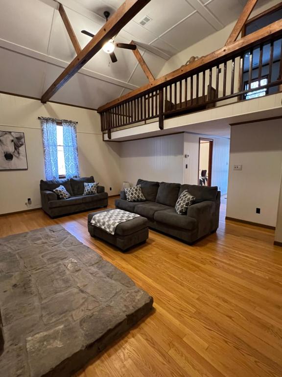 a living room with two couches and a staircase at Buckhorn Cabin in Mathias