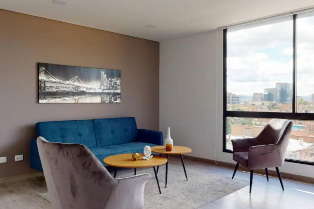 a living room with a blue couch and chairs at Apto 2 habitaciones Comfort Kappa in Bogotá