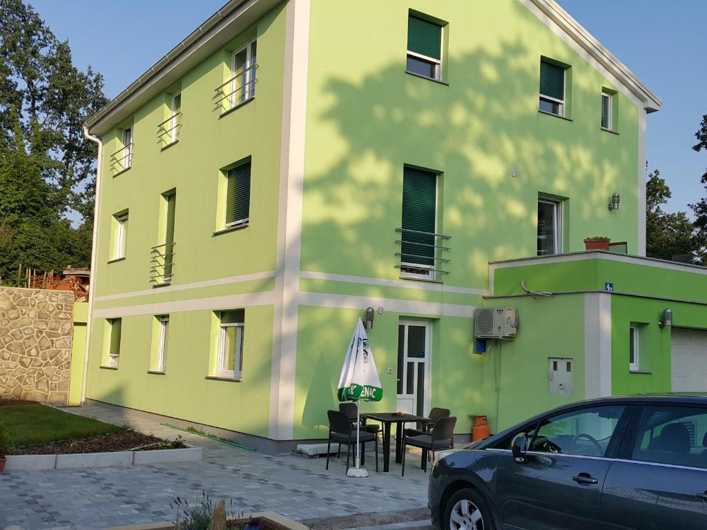 a building with a car parked in front of it at Apartments Carmen in Jurdani