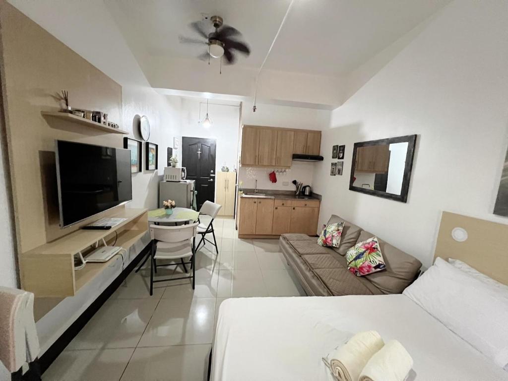 uma sala de estar com um sofá e uma televisão em San Marino Residences em Cebu