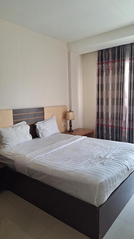 a large bed in a bedroom with a window at D'Sapphire Hasanah Guesthouse in Blimbing
