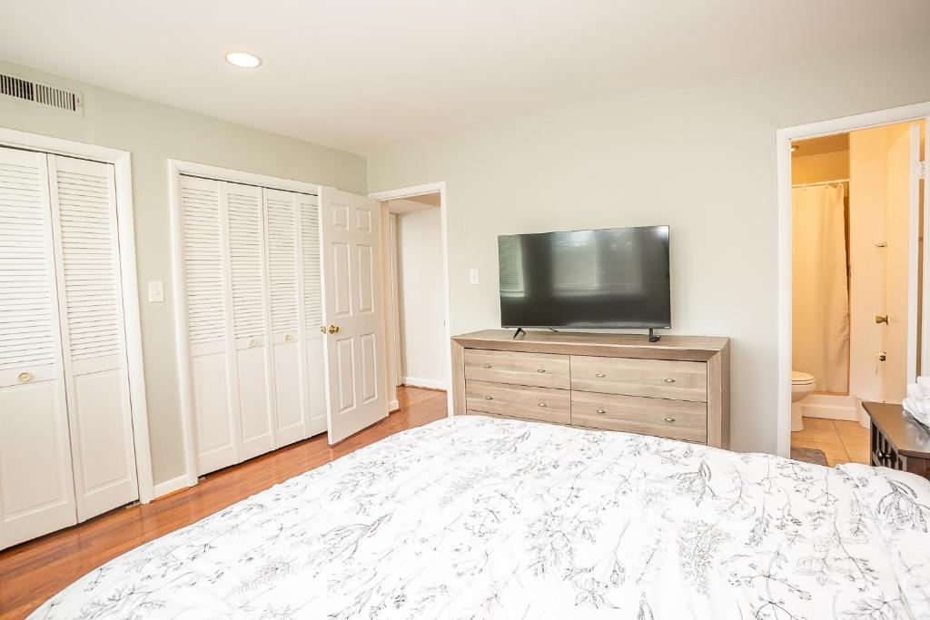 a bedroom with a large bed and a flat screen tv at Comfy and Cozy-Min to National Mall Great Location in Arlington