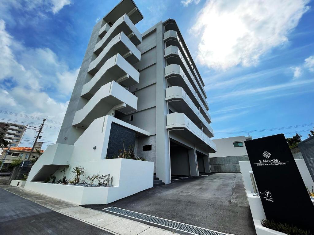 um edifício branco com aiger em ＆Monde. Okinawa Arena Condominium em Okinawa