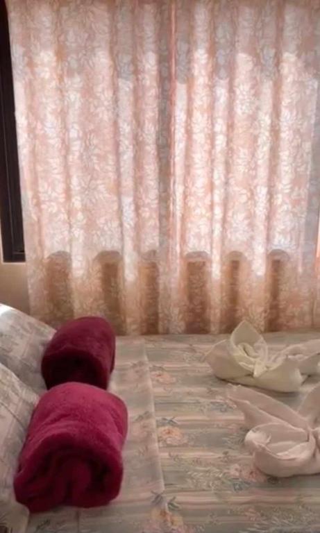 two towels on a bed in front of a window at Ria's Pension in Puerto Princesa City