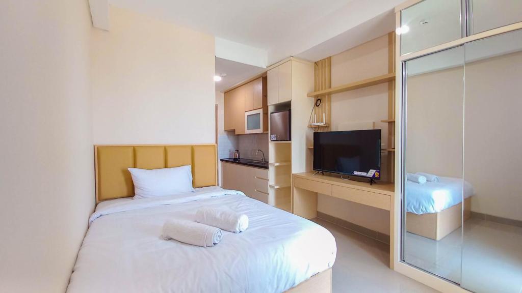 a hotel room with a bed and a television at Ayostay at B Residence Serpong in Cilandak