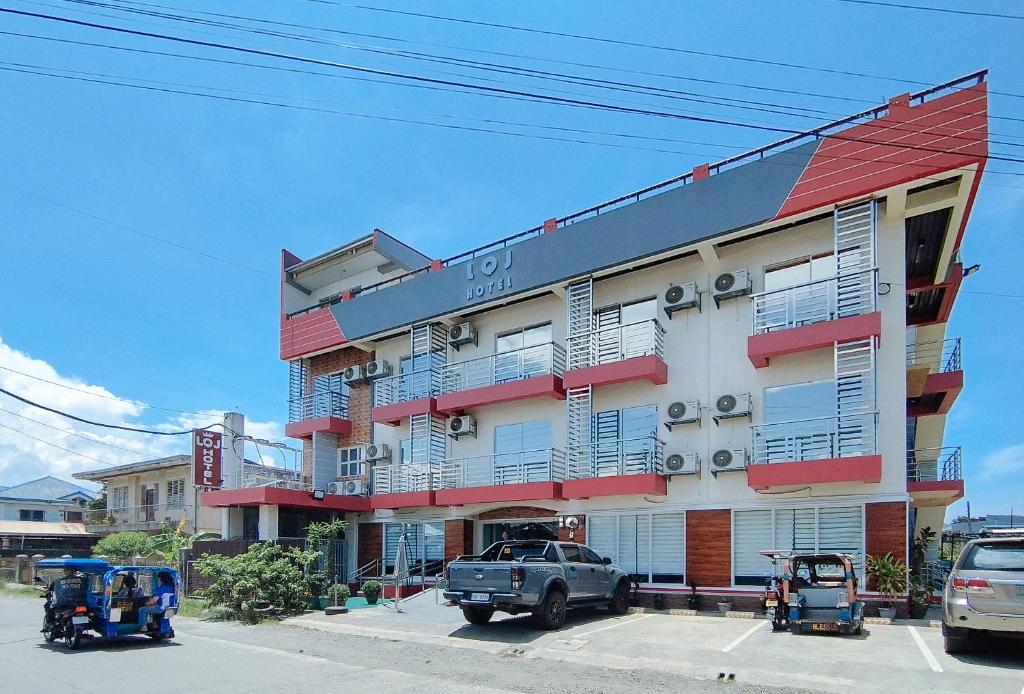 a building with cars parked in front of it at RedDoorz @ LQJ Hotel Old Buswang Kalibo in Kalibo